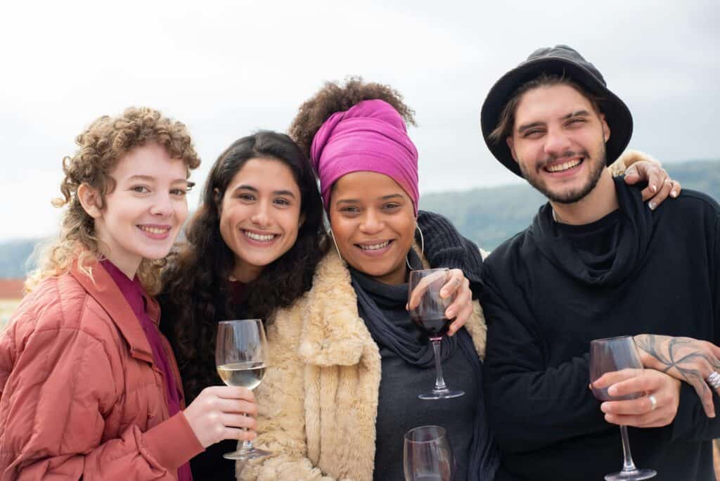 A man and three women enjoying drinking some wine